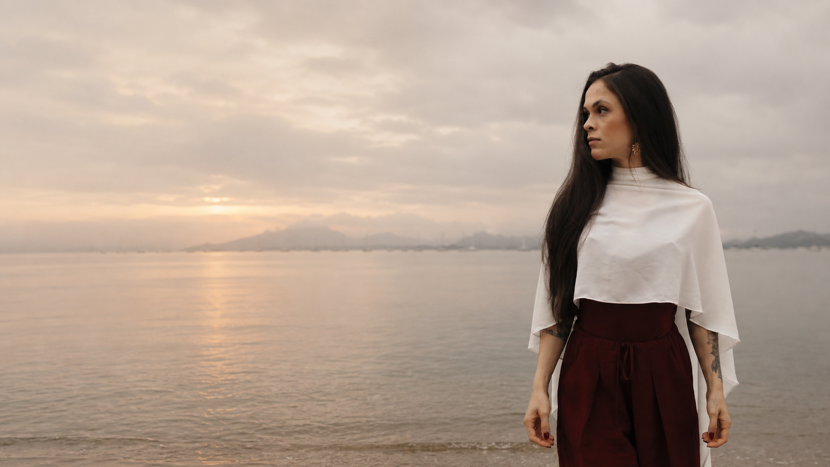 Mulher olhando o mar ao amanhecer